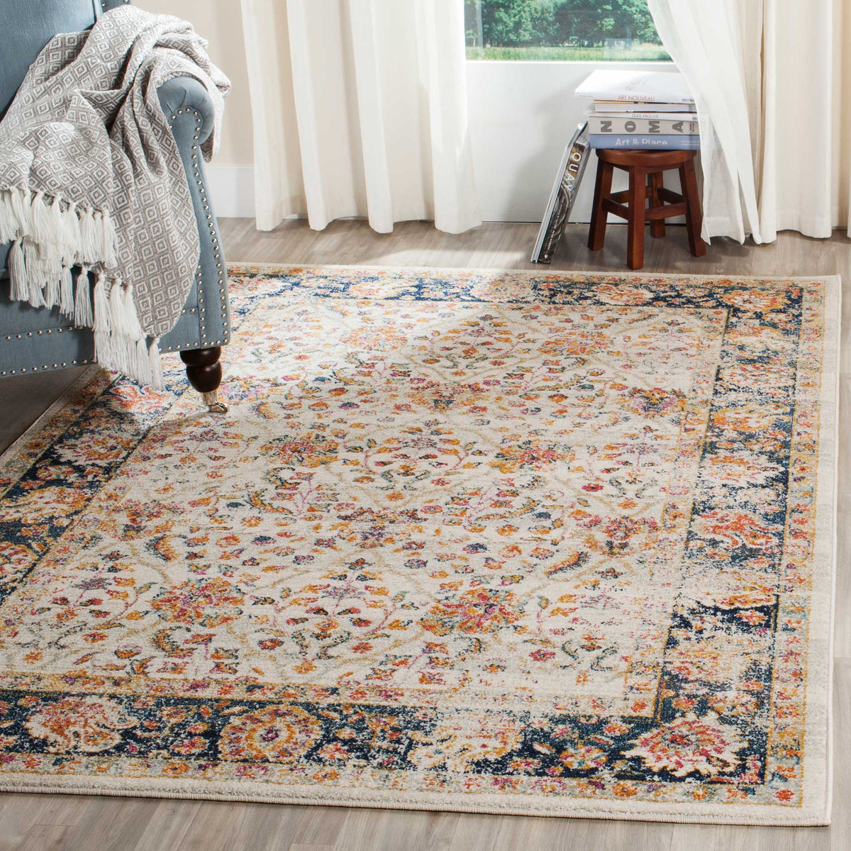 A cream and navy floral rug brightens the living room with its colorful border and ornate design.