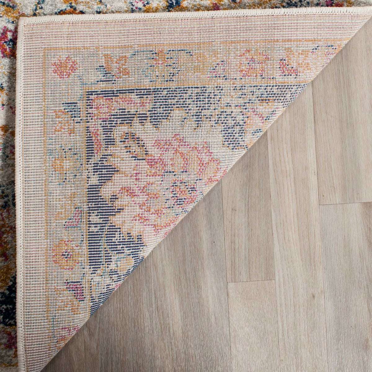 Woven backing and a neatly finished edge support the rug's colorful floral design.