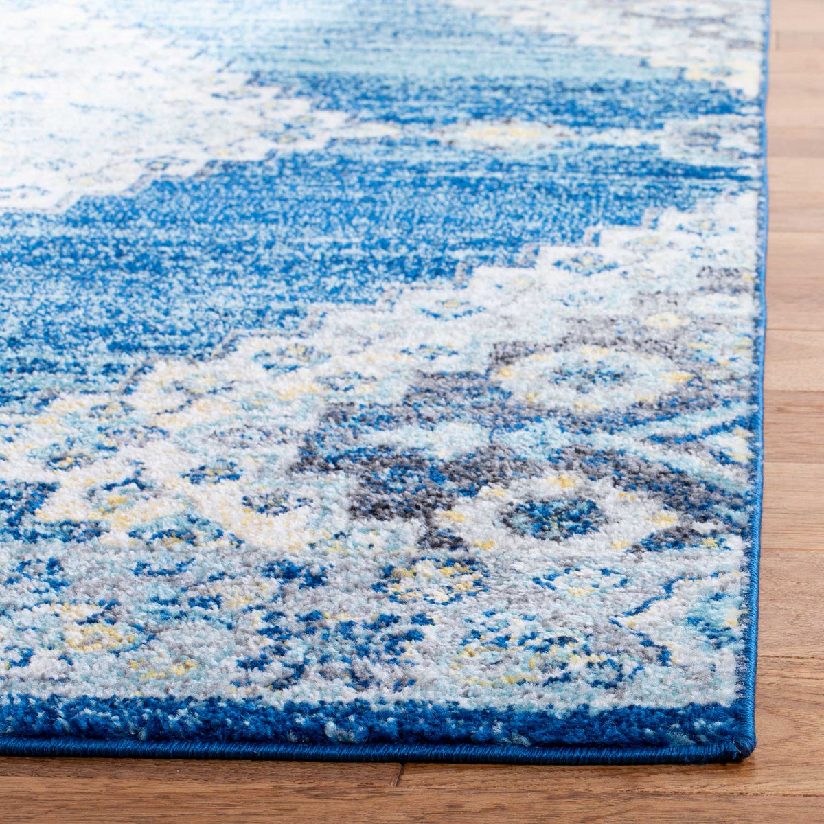 A navy bound edge accents the rug's textured blue and cream floral design.