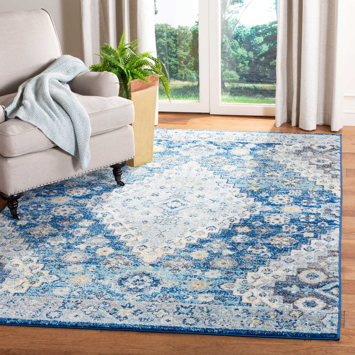 A navy and creme rug brings a softly distressed floral pattern to a bright living room
