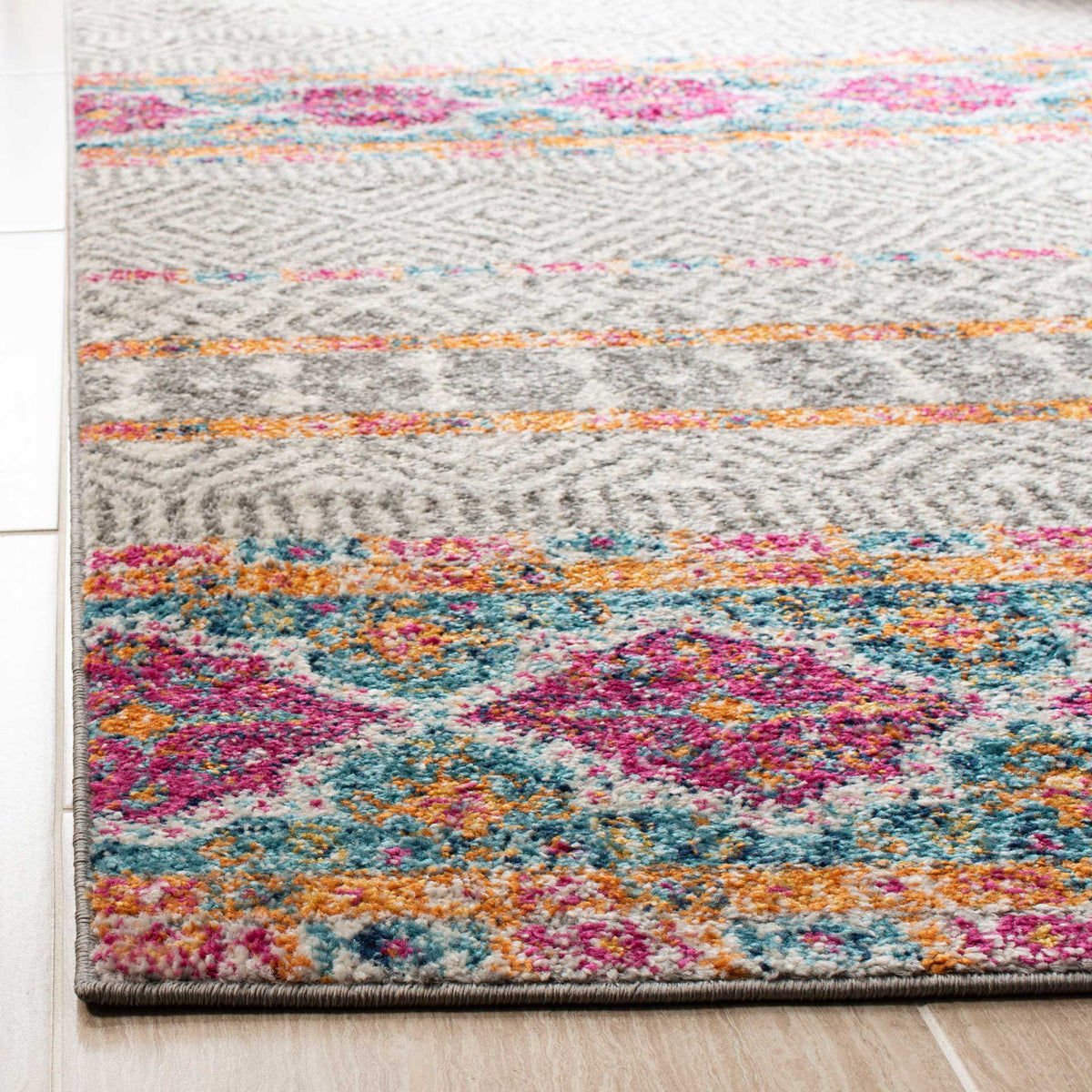 Colorful medallions meet fine gray geometrics and a neatly bound rug edge.