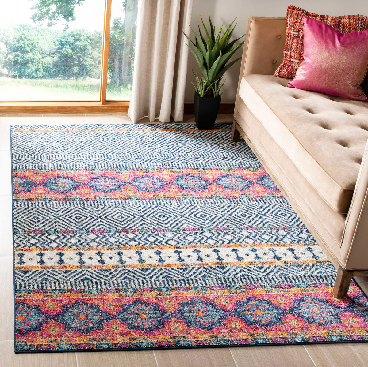 Navy and ivory diamond bands anchor vivid pink and orange medallions in a welcoming living space.