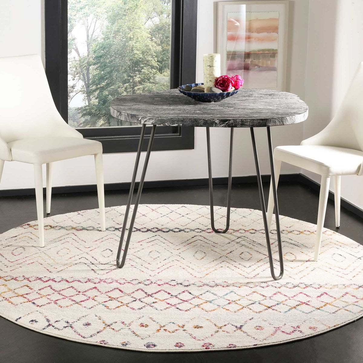 Colorful geometric patterns enliven a round ivory rug beneath a dining table