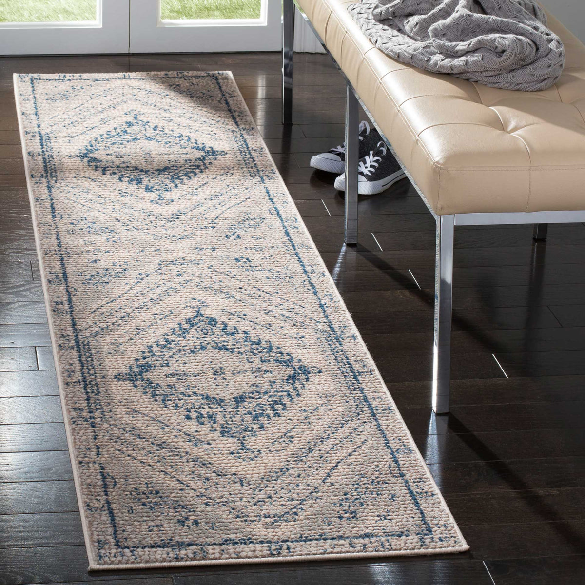 Low-profile runner adds softly faded navy motifs to a light-filled entryway