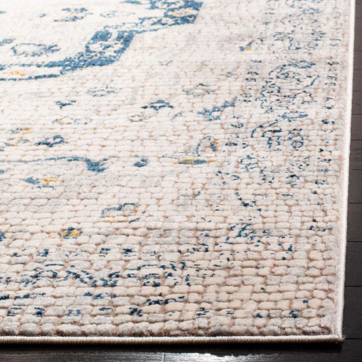 Textured ivory pile brings out the distressed navy motifs and neatly finished edges of this rug