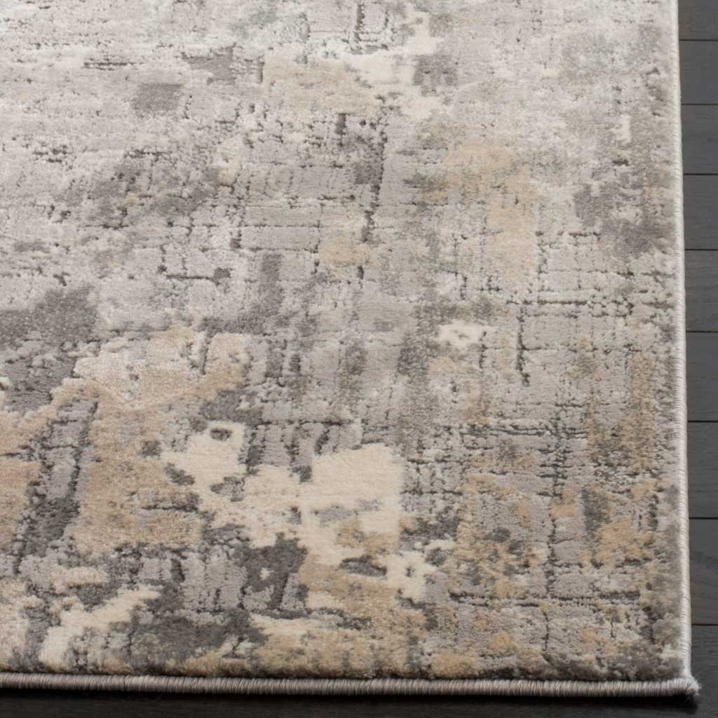 Textured gray and beige fibers meet a neatly bound edge on this abstract area rug.