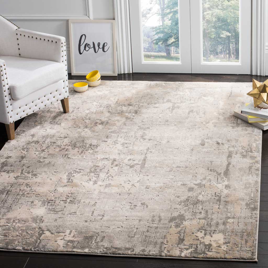 Muted gray, ivory, and beige tones form a distressed abstract rug that softens a living space.