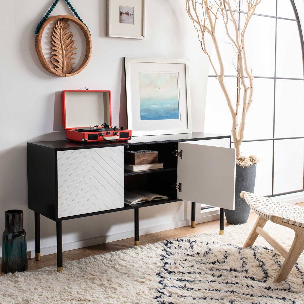 White cabinet doors open to show dark shelves for books beneath a black display top