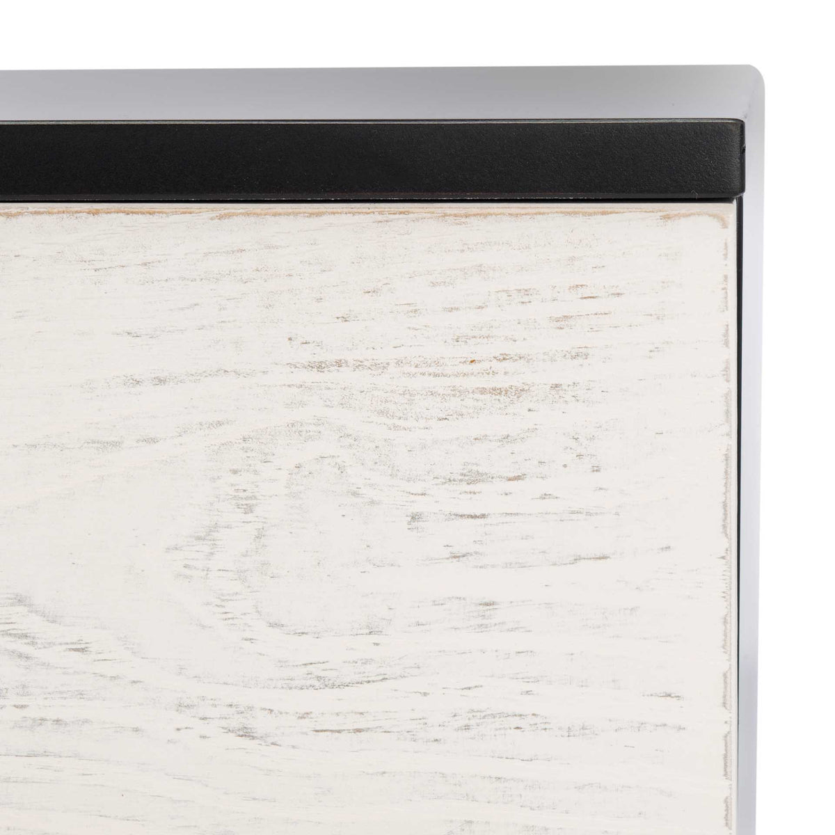 Subtle wood grain shows through the whitewashed door beneath the sharp black tabletop edge.
