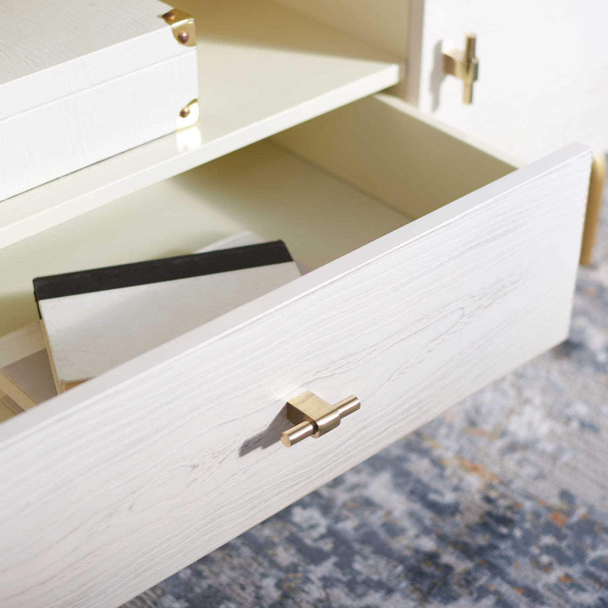 An open whitewashed drawer offers space for accessories beneath the cream-colored central shelf.