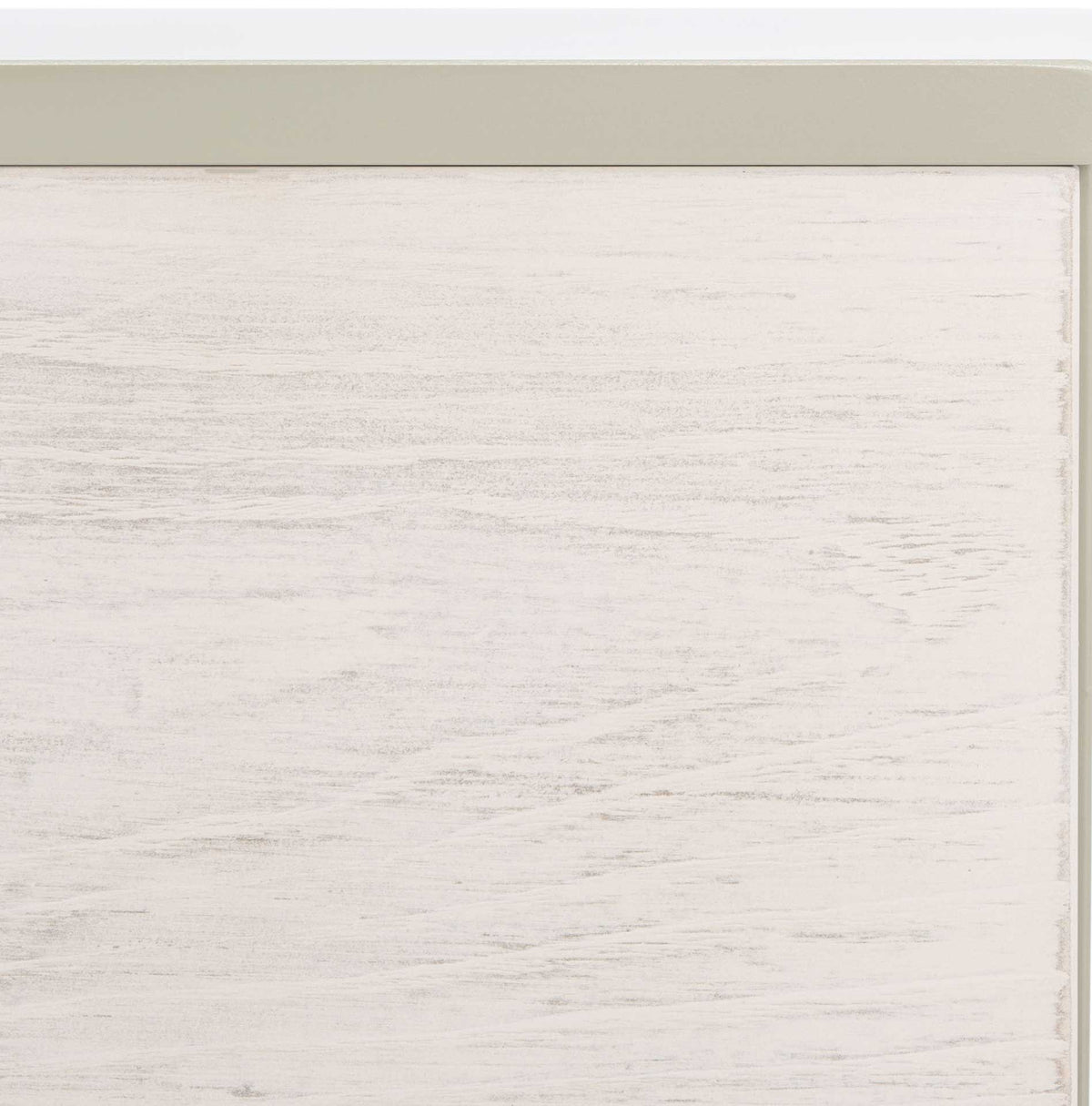Lightly grained whitewashed wood meets the muted gray edge of the cabinet top.