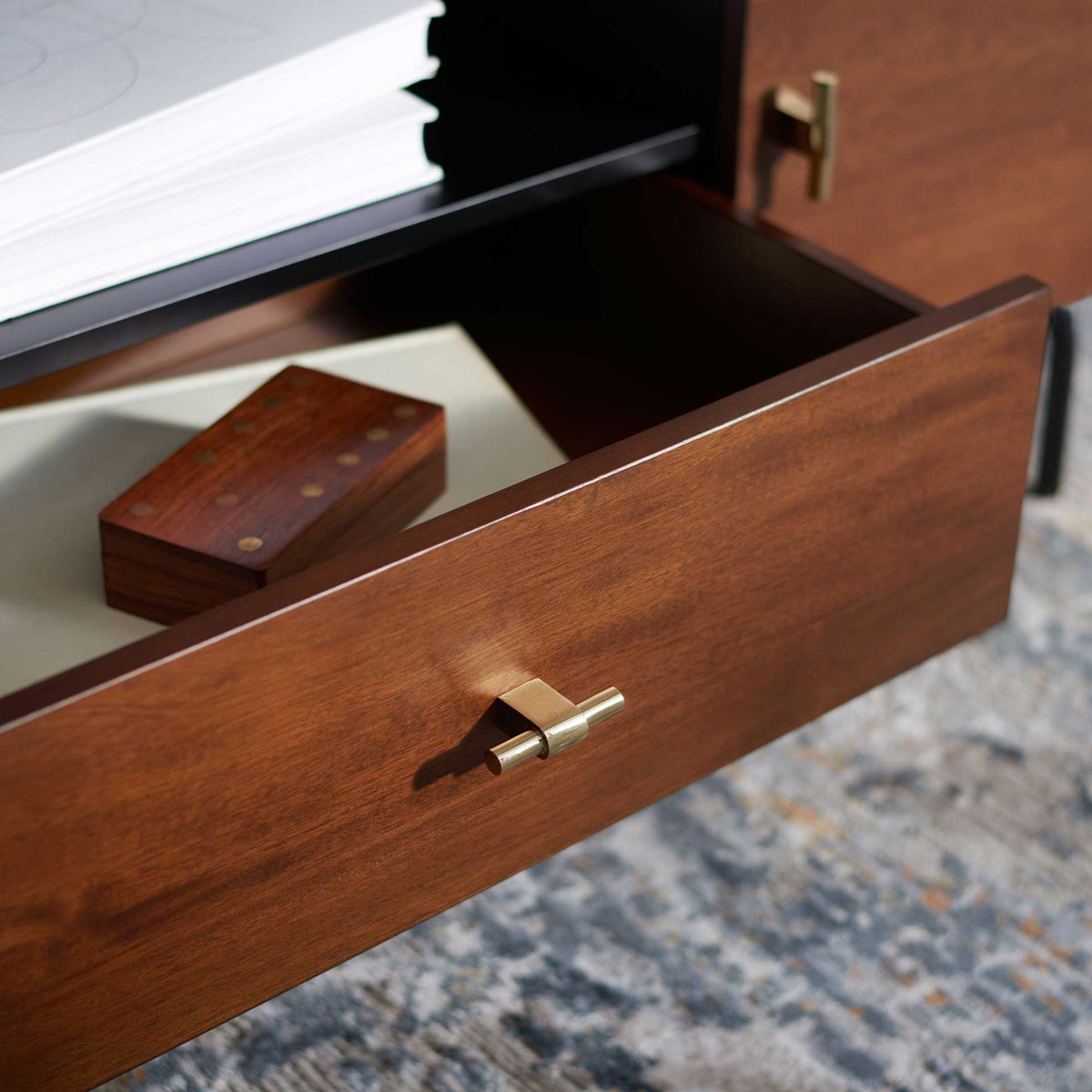 An open walnut drawer keeps small essentials at hand beneath the spacious black shelf.