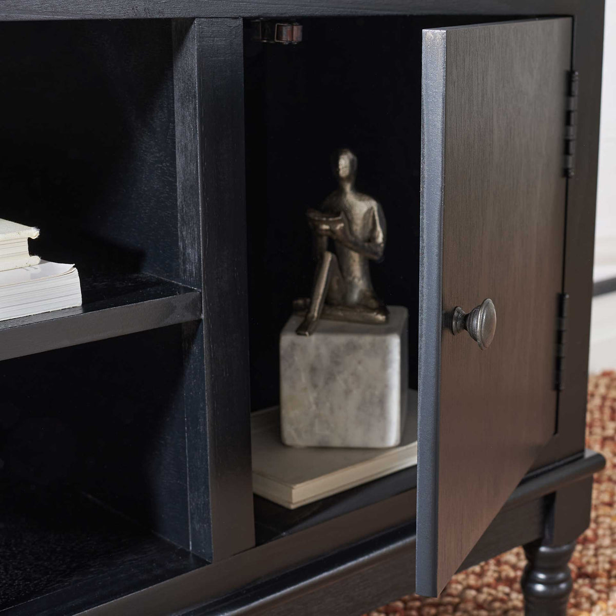 The hinged black door opens to cabinet storage alongside spacious center shelves.