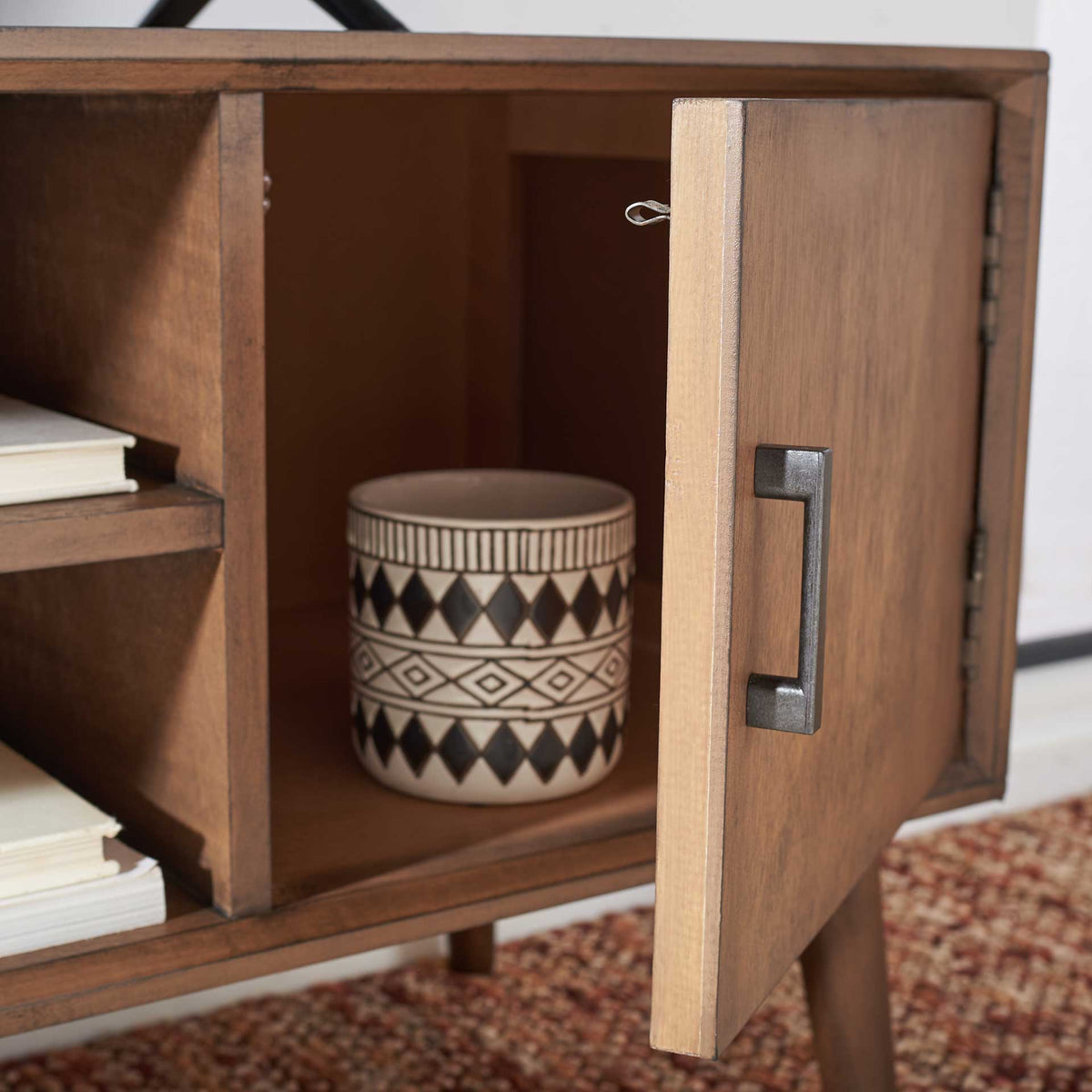 A brown side cabinet opens to reveal storage for decor and everyday essentials.