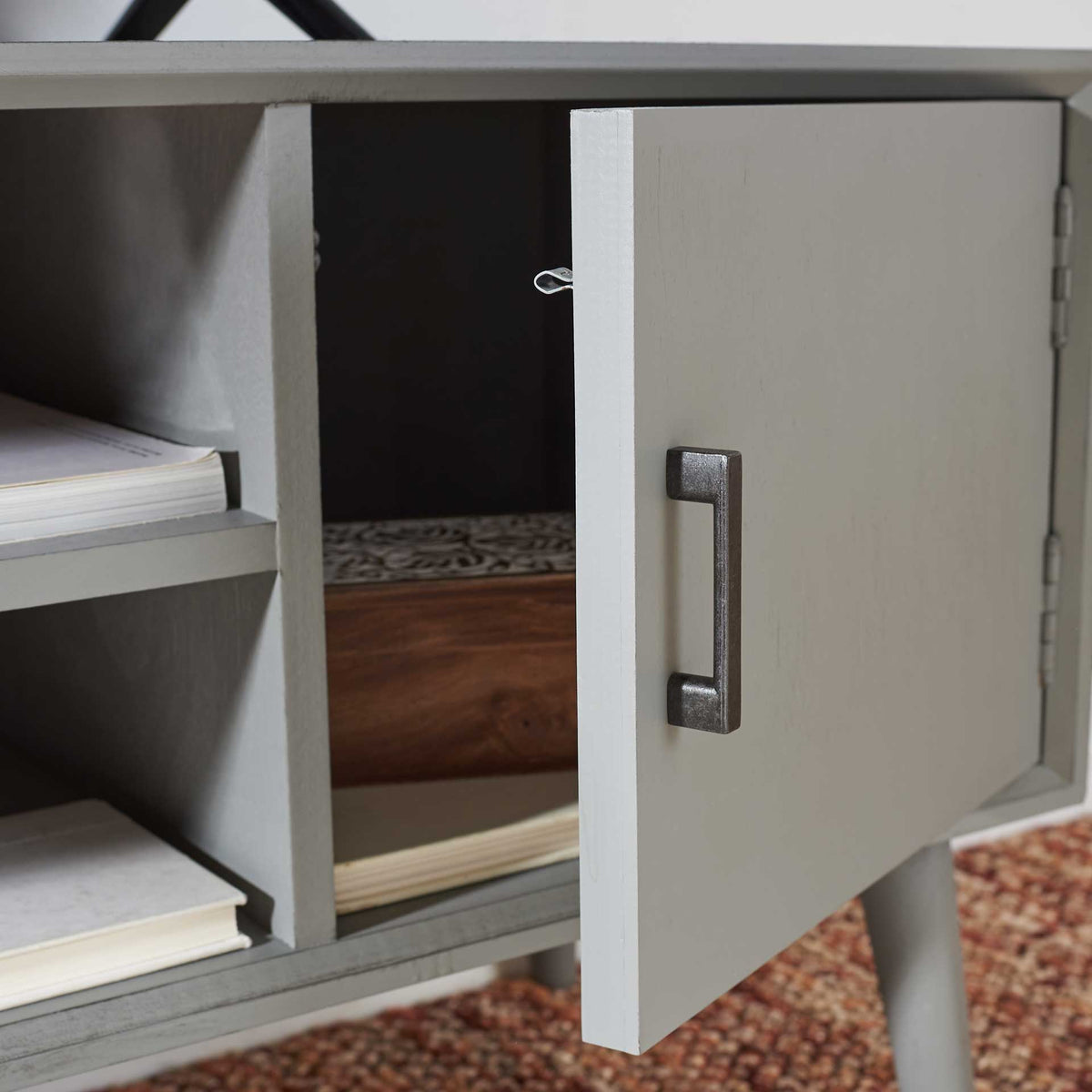 The gray side cabinet opens for hidden storage beside its open display shelves.