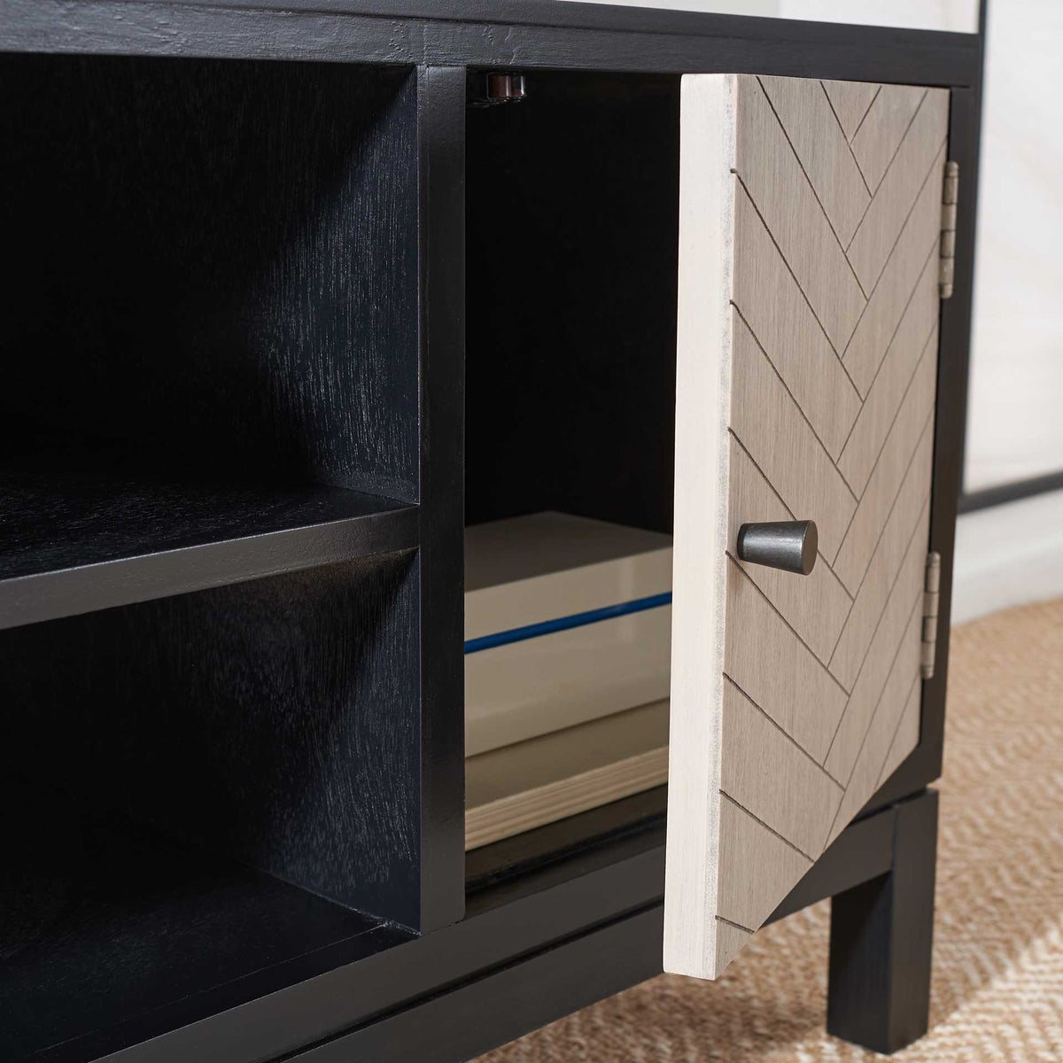 An open greige door reveals cabinet storage beside two roomy black shelves.