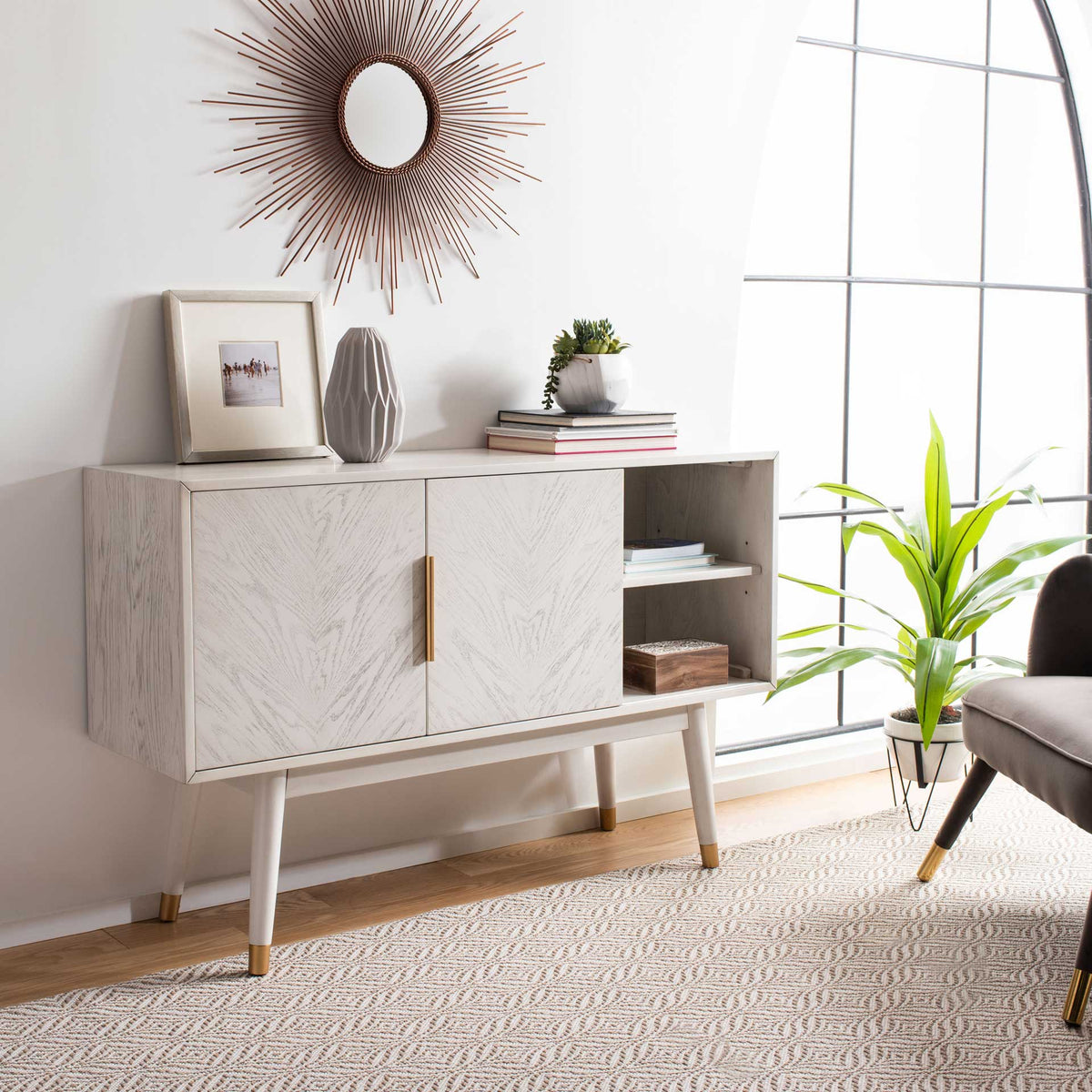 A sliding door reveals a side shelf for books and decor beneath the whitewashed top.