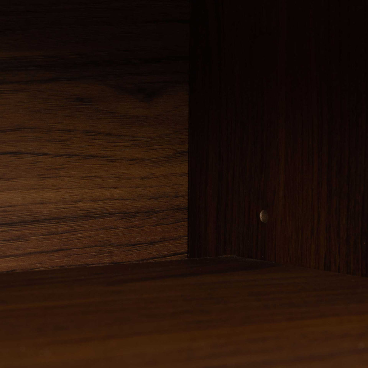 Warm wood-grain finish continues inside the storage cubby for media accessories.