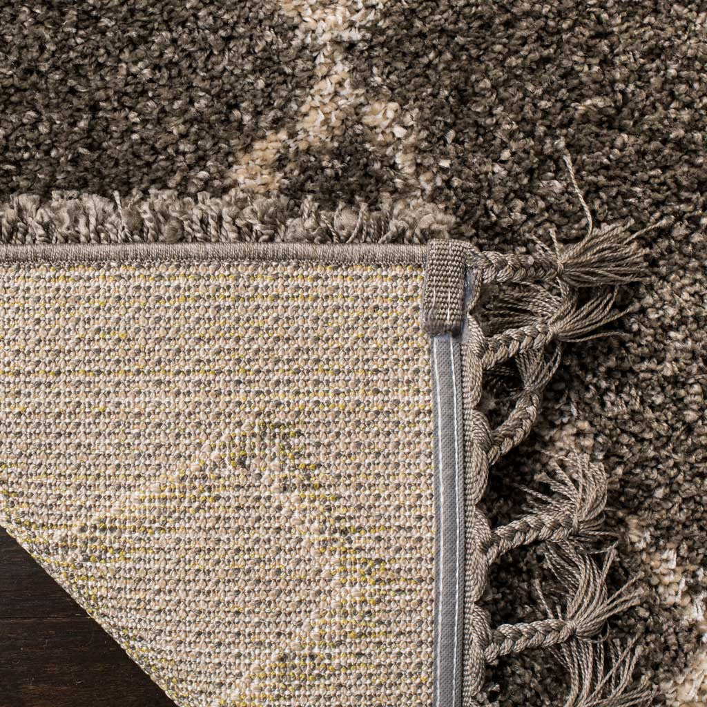 A woven underside folds beneath the soft gray pile and braided tassels