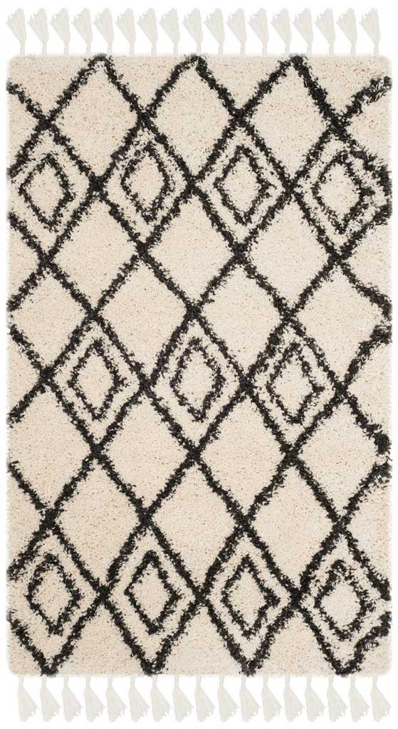 Nested charcoal diamonds repeat across a small cream rug with pale fringe