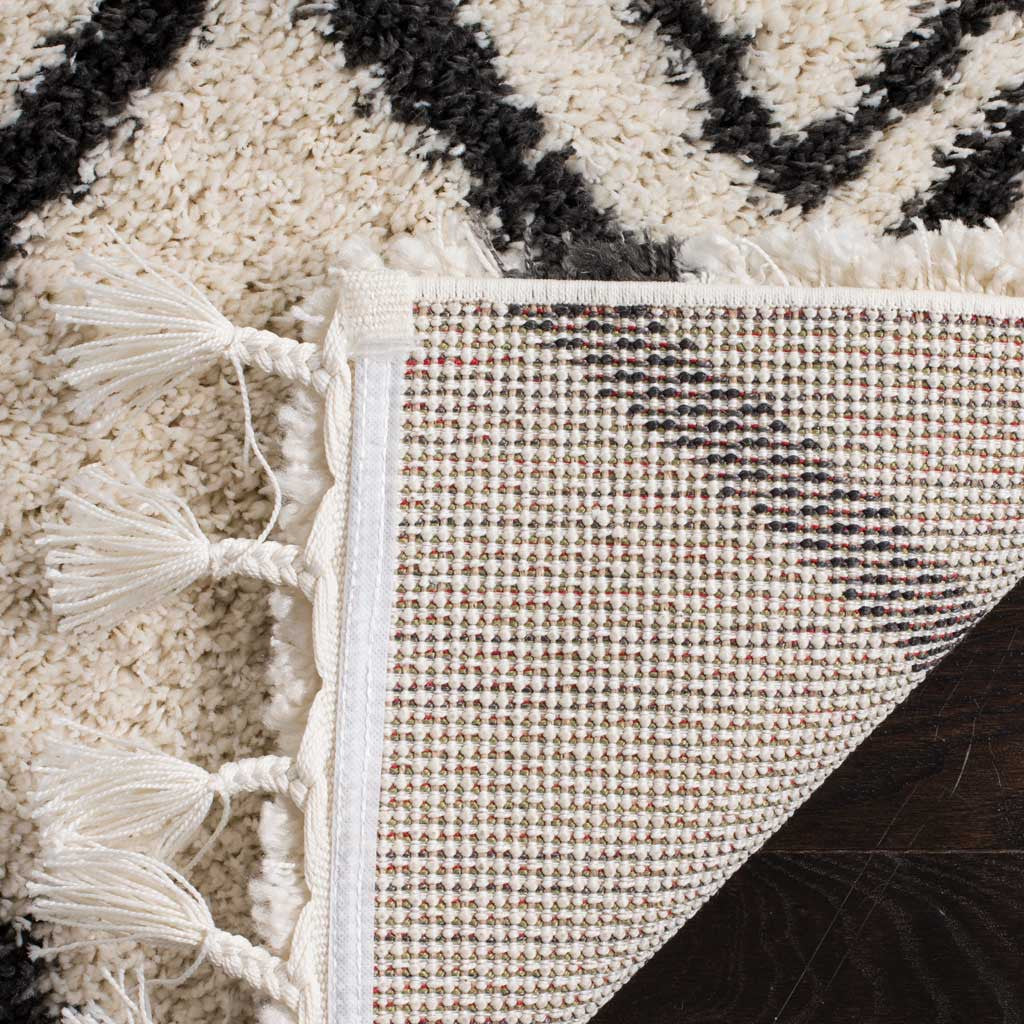 A close weave backs the cream shag and its long, white knotted fringe