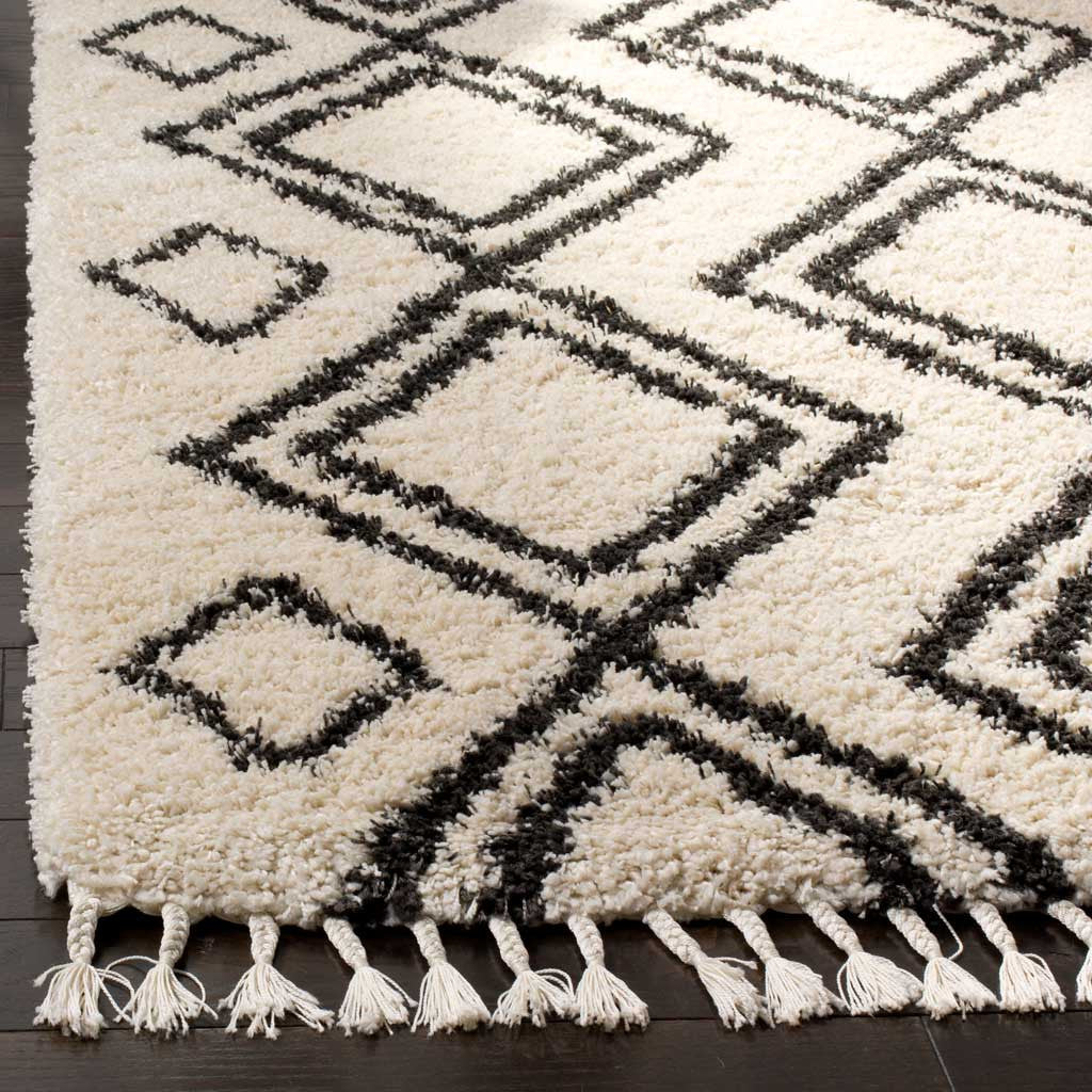 Plush cream pile and bold charcoal outlines meet a row of long tassels