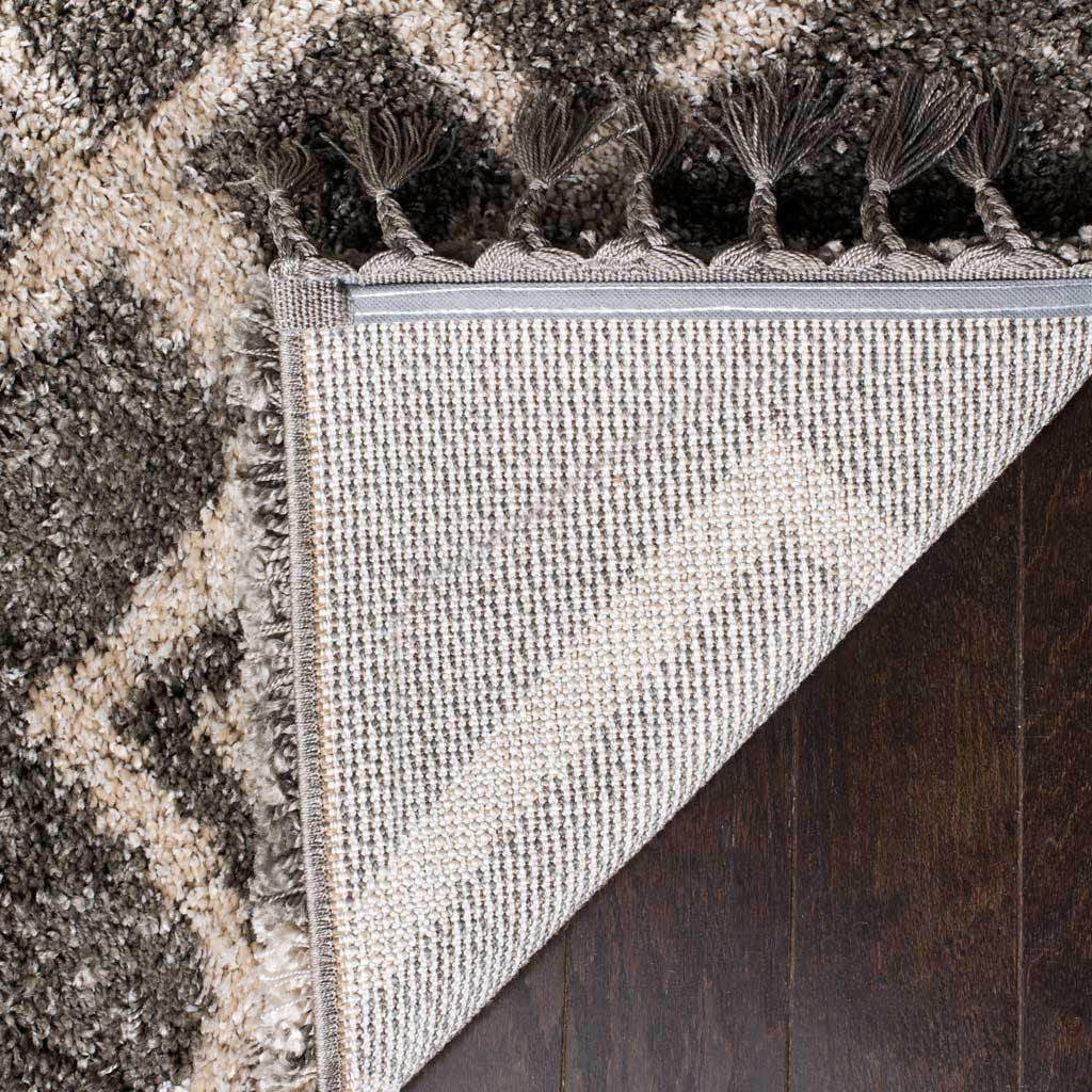 Woven fabric backing adds structure beneath plush gray pile and braided fringe