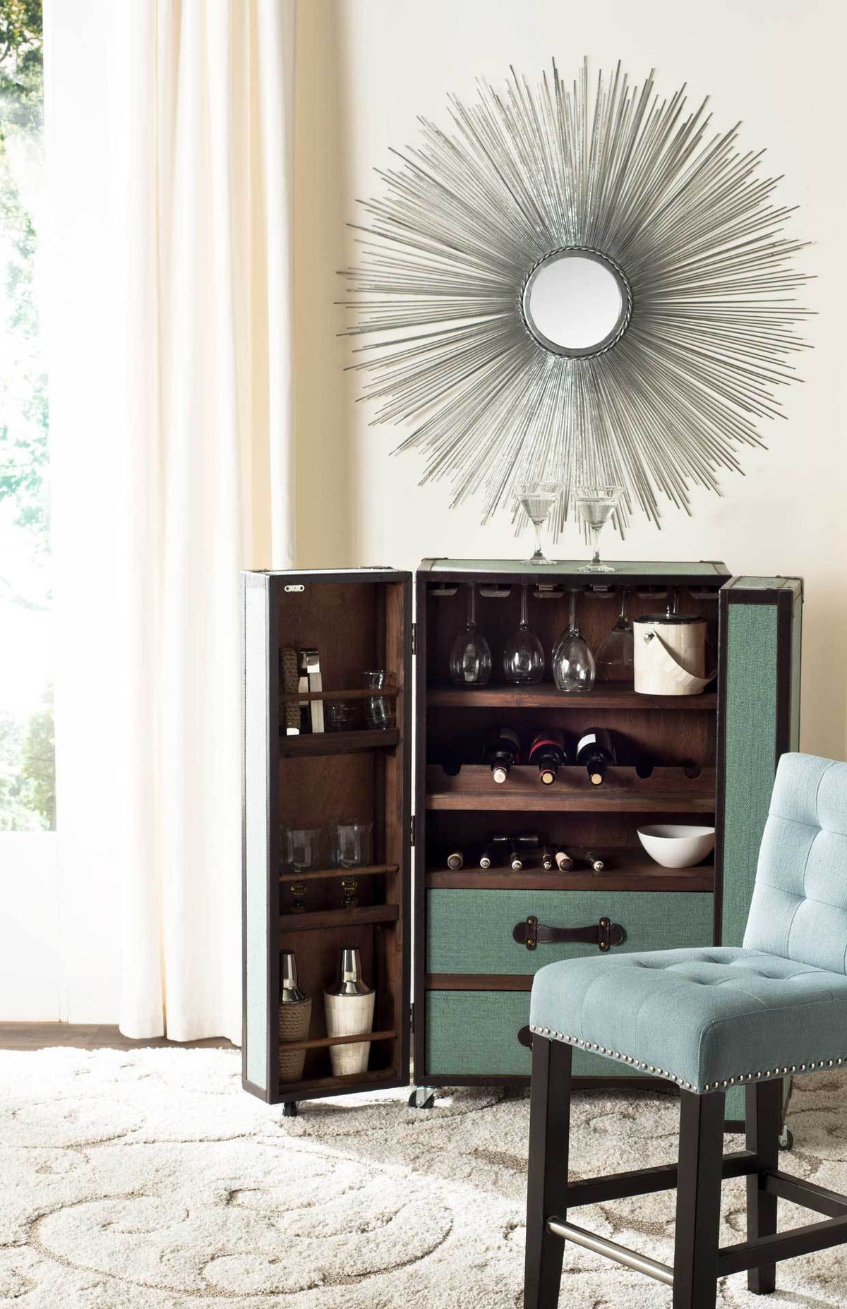 An airy silver sunburst mirror adds a focal point above a cabinet