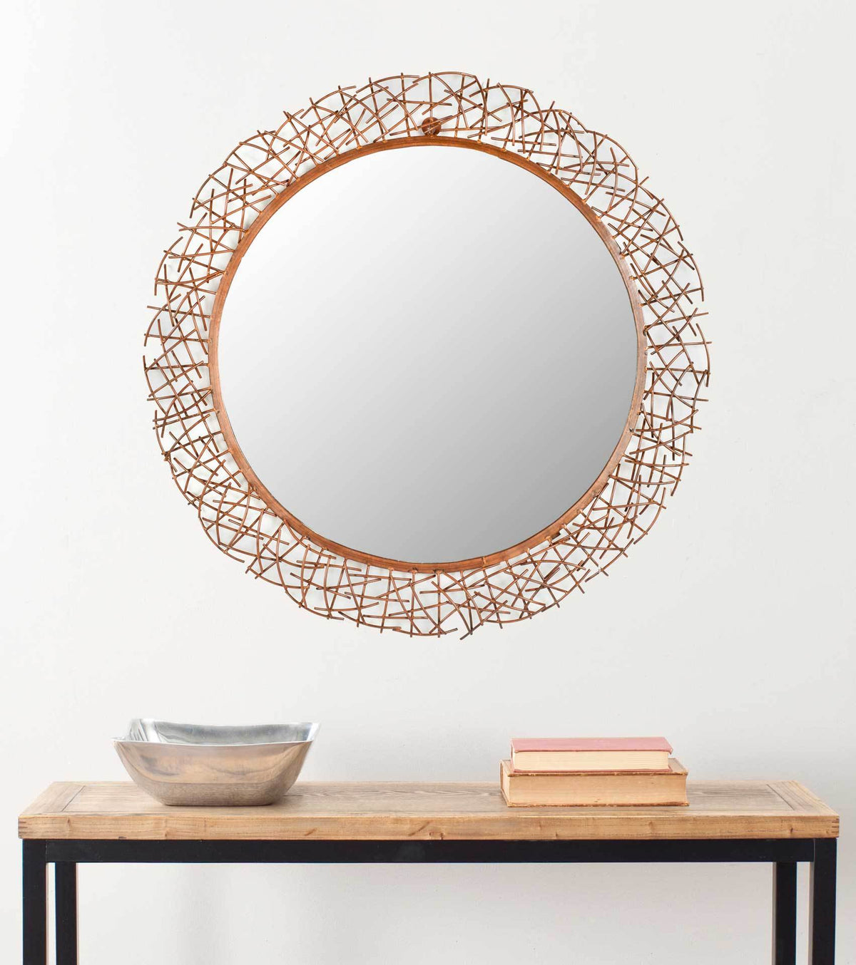 A copper-toned twig mirror brings warmth and organic texture to a wall above a console
