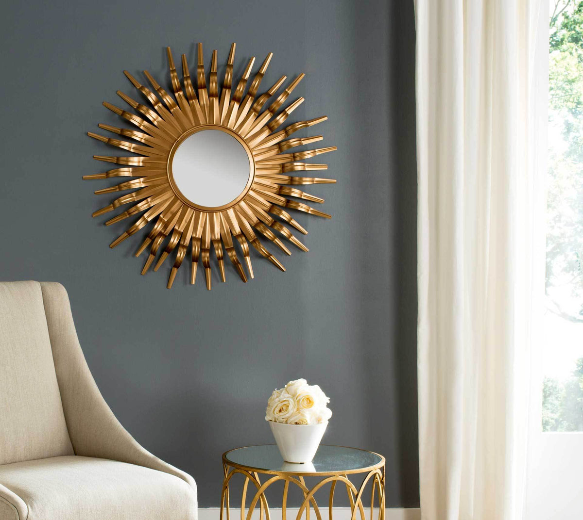 A gold sunburst mirror gives a charcoal wall a warm, radiating accent