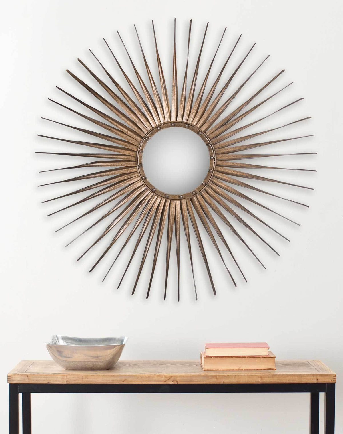 A gold sunburst mirror brings warmth to the wall above a wood-topped console.
