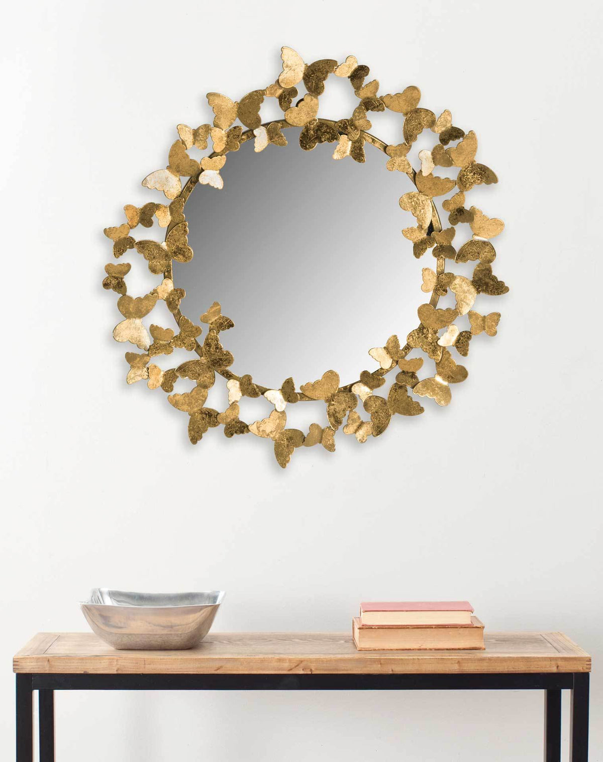 Gold butterfly-framed mirror adds a playful accent above a console table