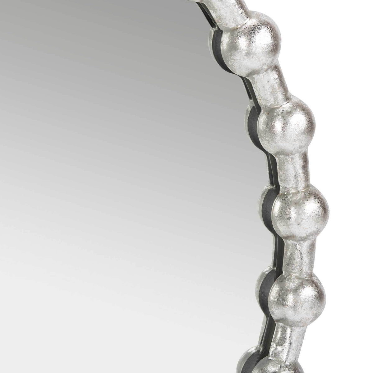 Raised silver beads give the mirror's decorative edge depth and texture.