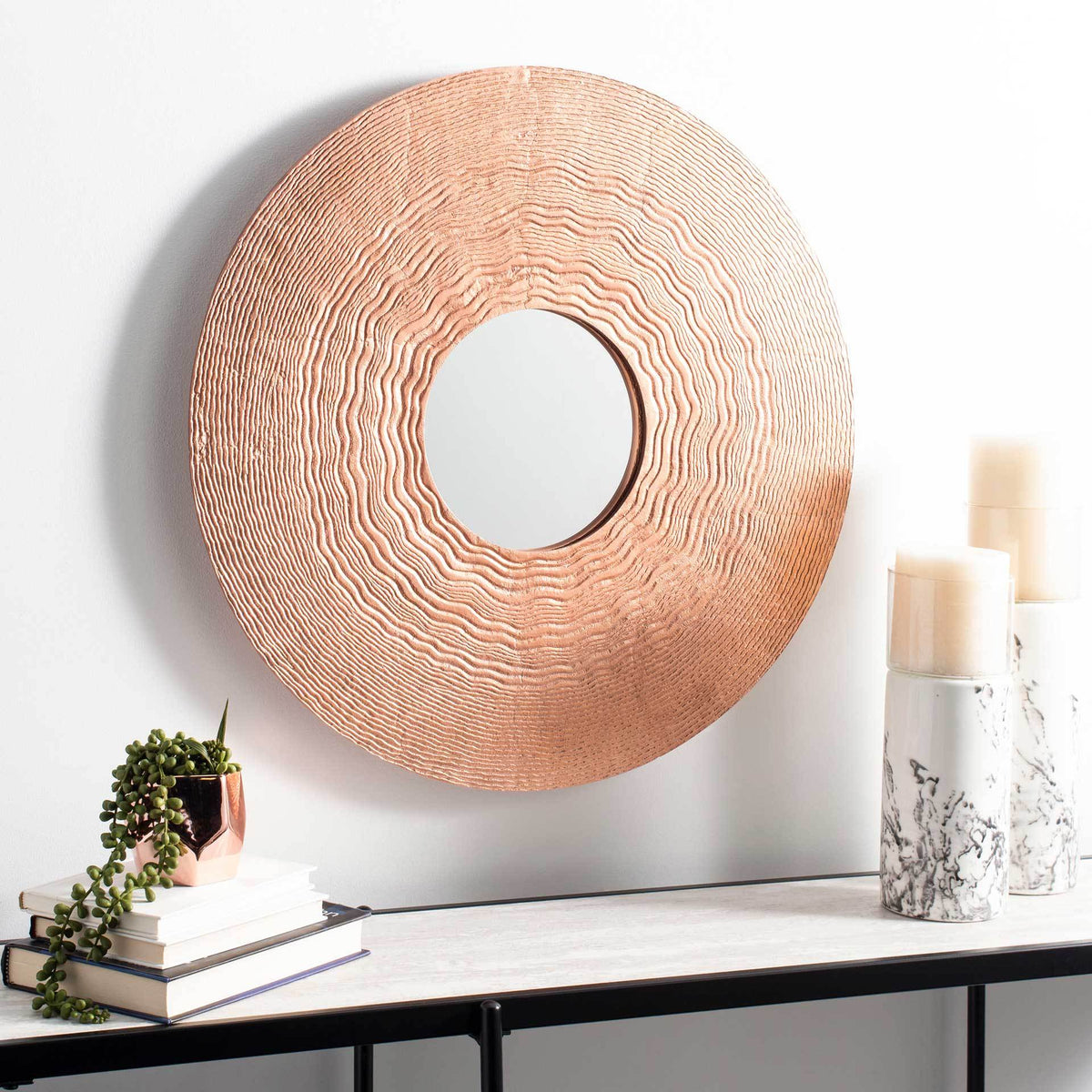 Textured copper mirror adds warmth above a console table