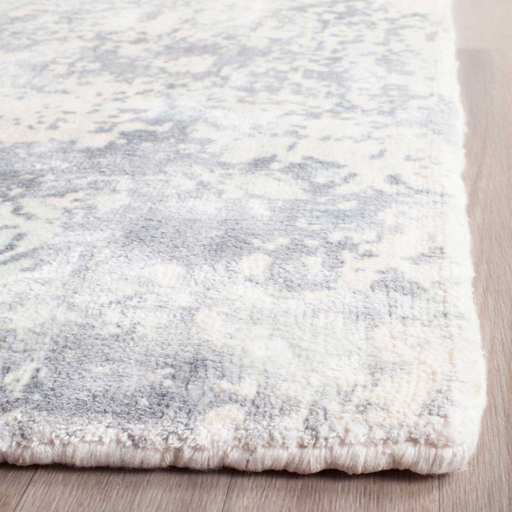 A textured, pale aqua pile meets the rug's thick, neatly finished edge