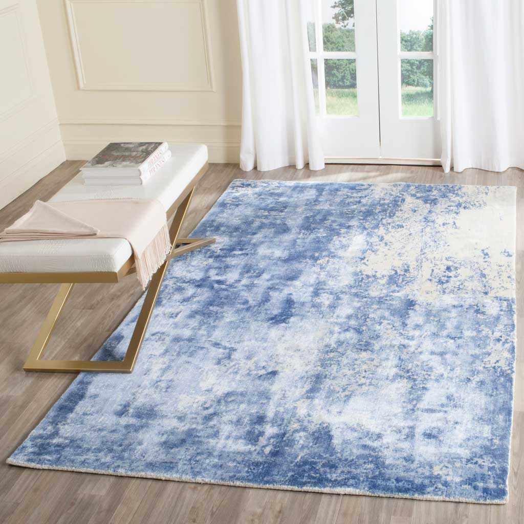 Rich blue tones fade into pale cream for an airy, watercolor-like rug design