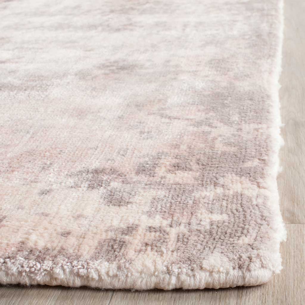 Soft pink and ivory pile reveals subtle color variation along a thick, finished edge