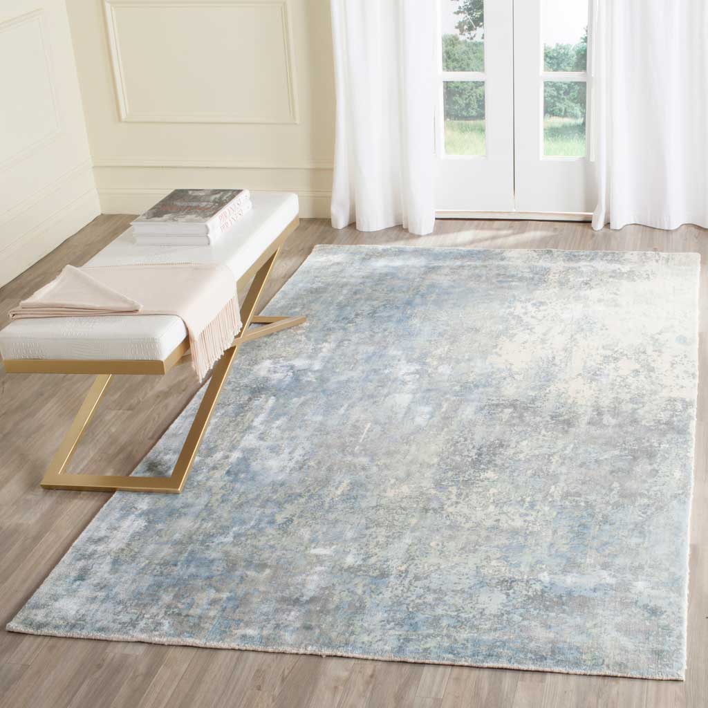 A pale aqua and ivory area rug adds a calm, cloudlike pattern beneath contemporary furnishings.