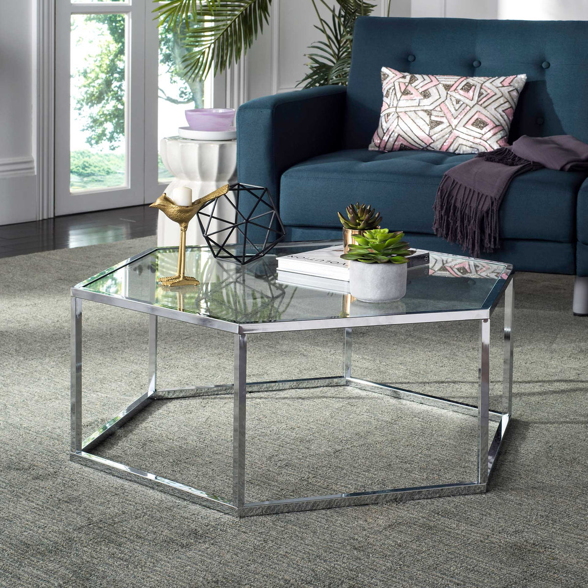 A glass-topped chrome coffee table brings modern shine to a cozy living room.