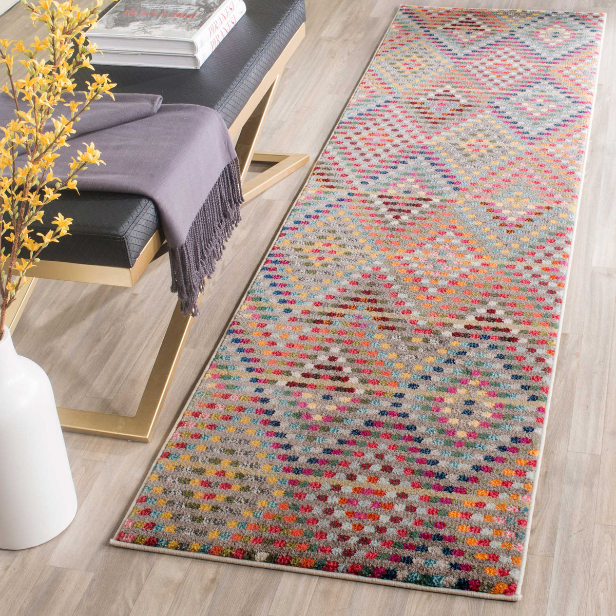 A colorful runner brings playful pattern to a pale wood floor beside a modern bench
