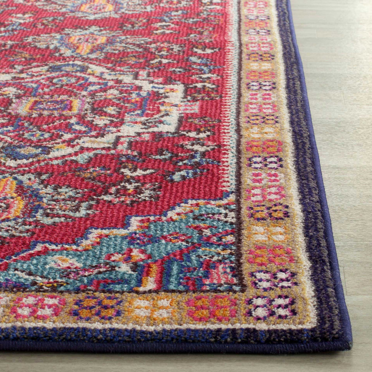 Textured red and turquoise motifs meet a multicolored border and neatly bound navy edge.