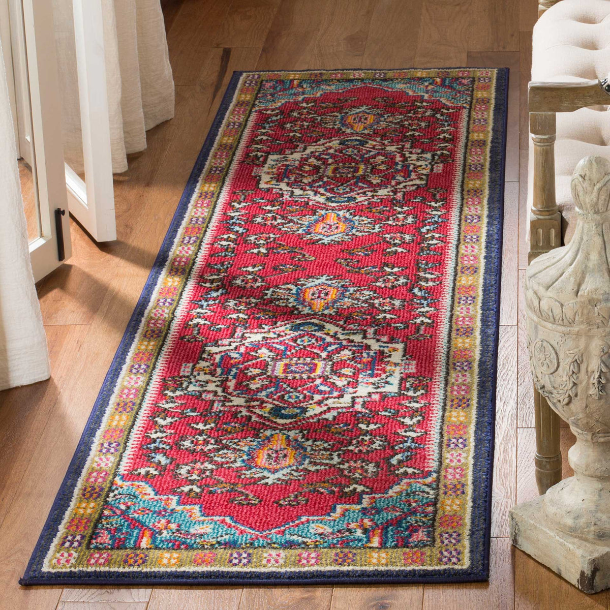 A rich red runner with turquoise flourishes and ornate medallions brings warmth to wood floors.