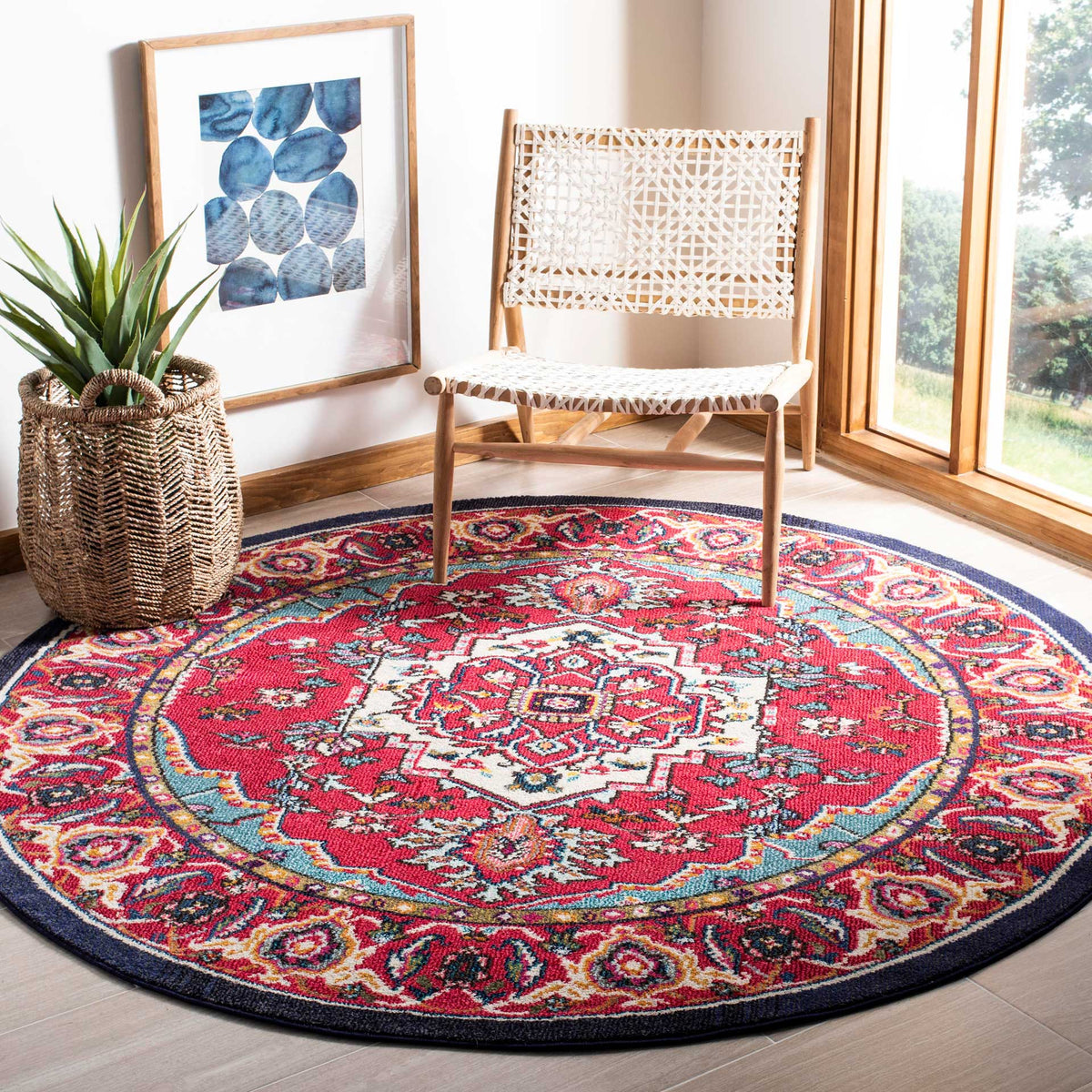 Ornate red and turquoise round rug brings vibrant pattern beneath a woven lounge chair