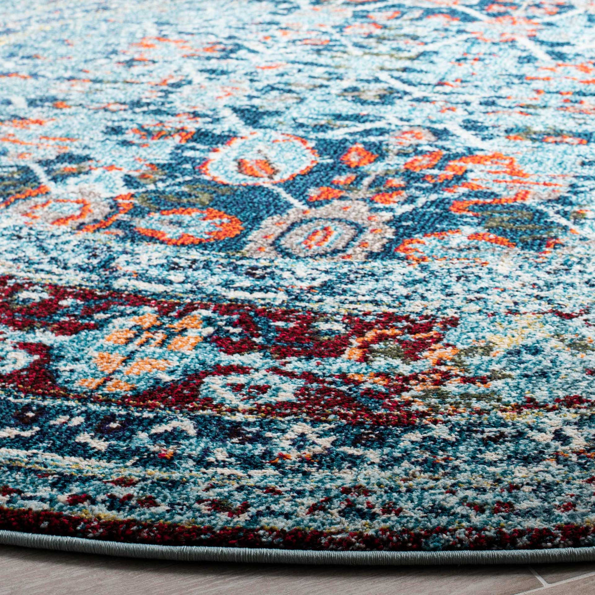 Blue and rust floral motifs enrich the textured pile above a neatly bound edge