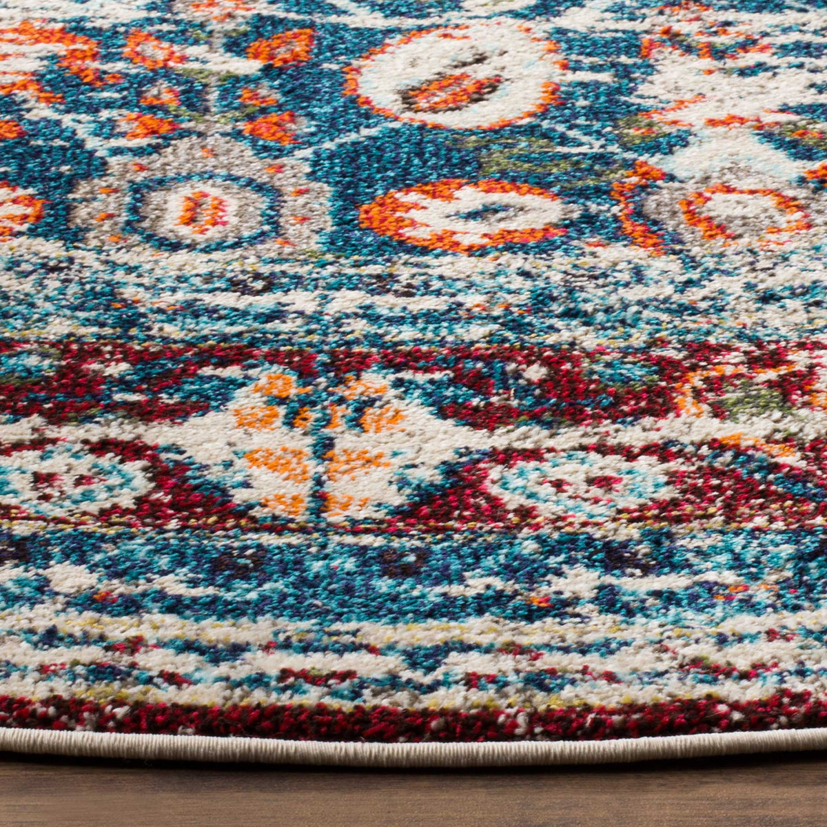 Ivory and blue floral motifs mingle with rust accents beside a neatly bound edge