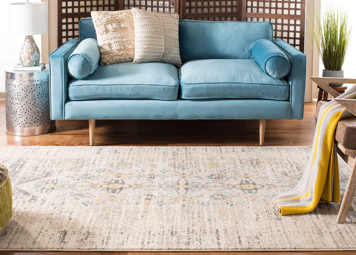 A pale gray patterned rug grounds a blue sofa with understated floral detail
