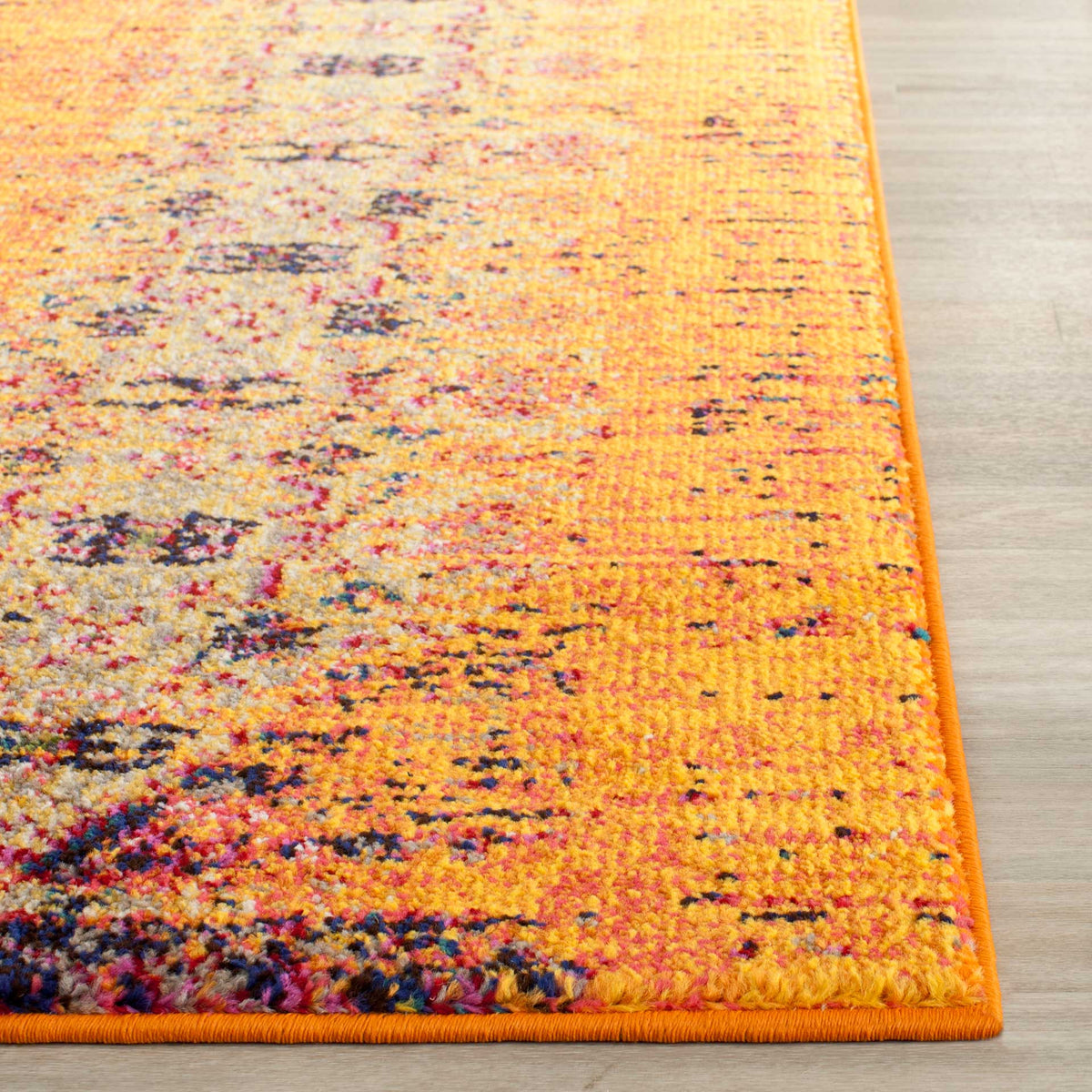 Neatly bound orange edges finish a textured surface with flecks of blue, pink, and gold.