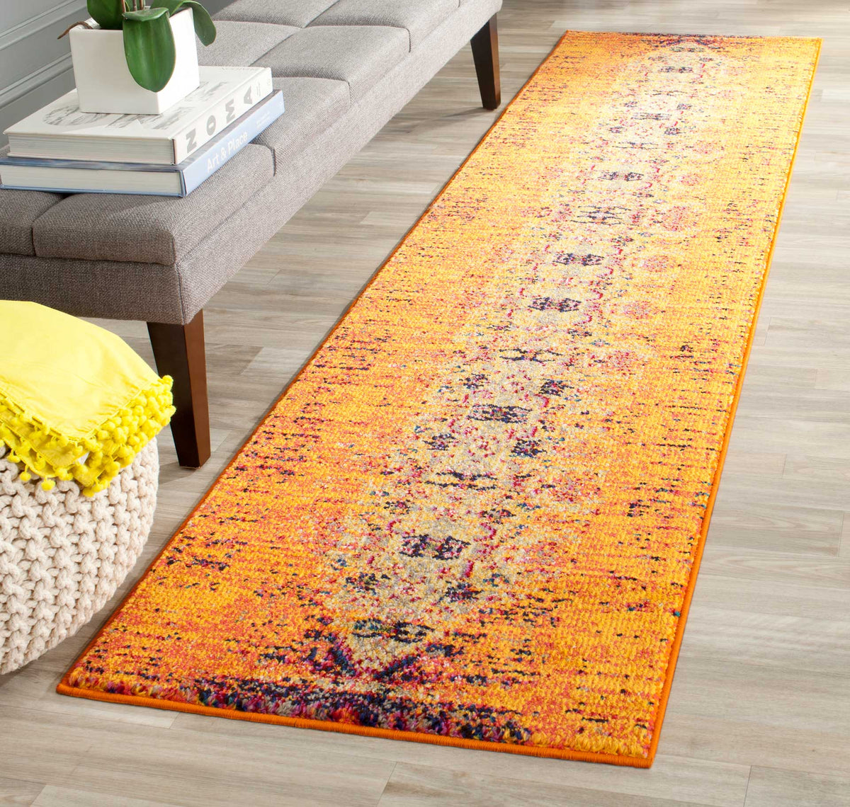 A brilliant orange runner warms pale wood floors with its softly faded traditional design.