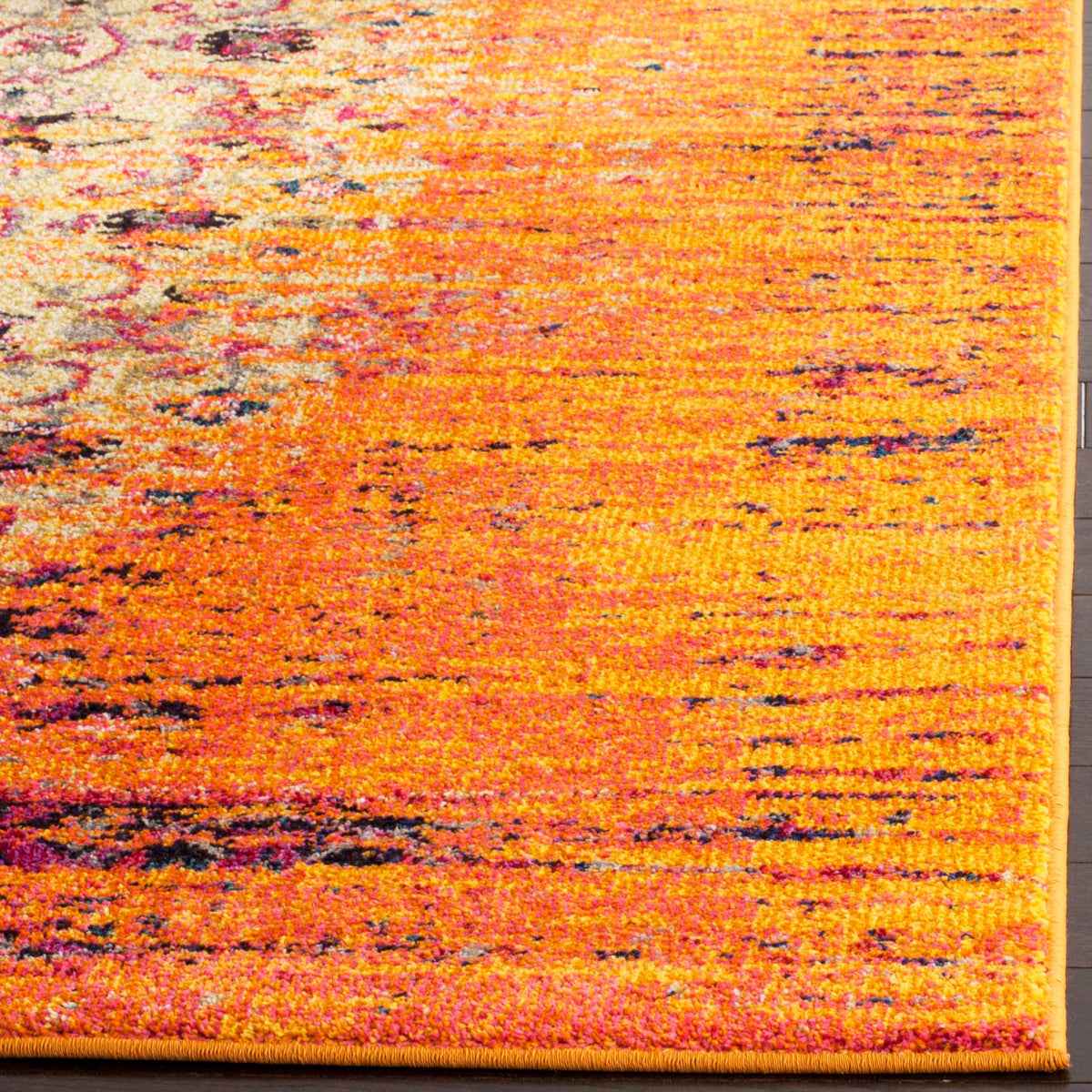 Vibrant orange pile shifts through pink and gold with specks of navy at a bound corner