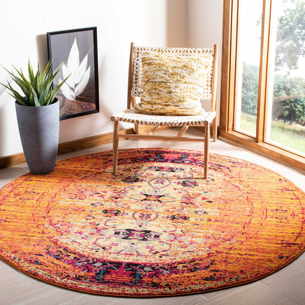 Vibrant orange round rug adds warmth with a distressed floral medallion and deep navy accents.